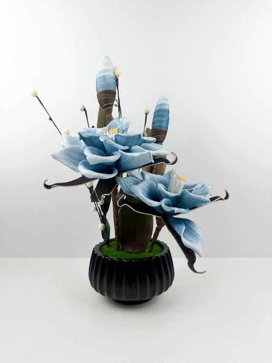 Fleurs bleu artificielles de qualité dans un pot noir haut de gamme