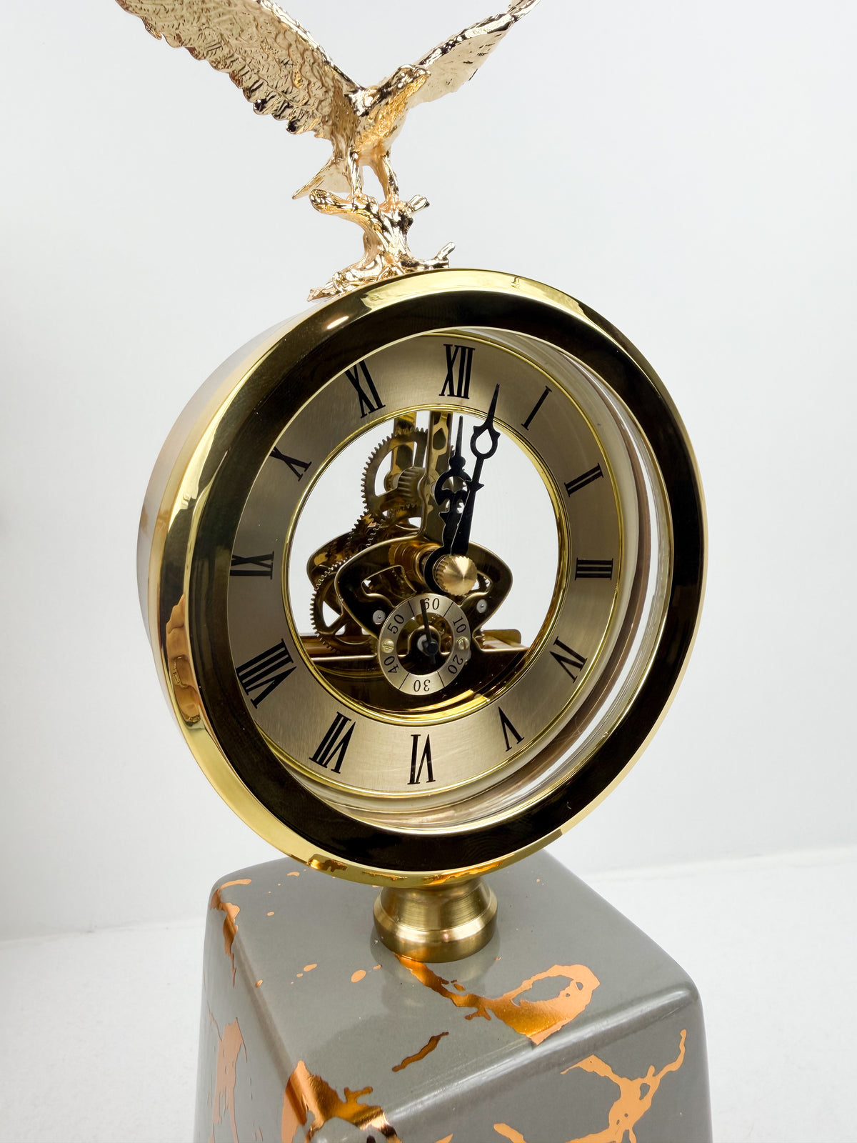 Horloge ronde avec cadran classique surmontée d'une sculpture d'aigle