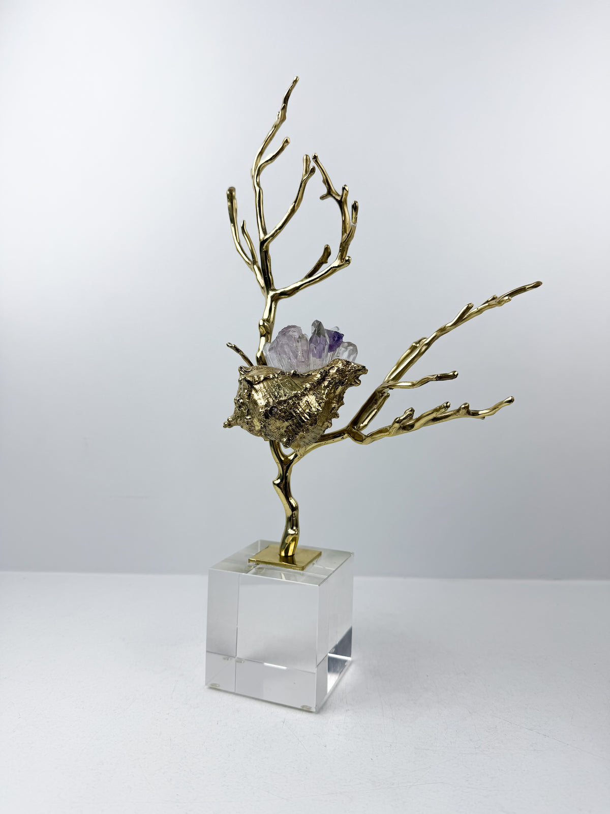 Sculpture de luxe de forme coquillage alliant l'élégance intemporelle du laiton doré aux reflets captivants des cristaux naturels.