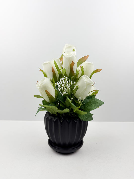 Fleurs artificielles blanches d'une élégance intemporelle dans un vase noir aux finitions impeccables.