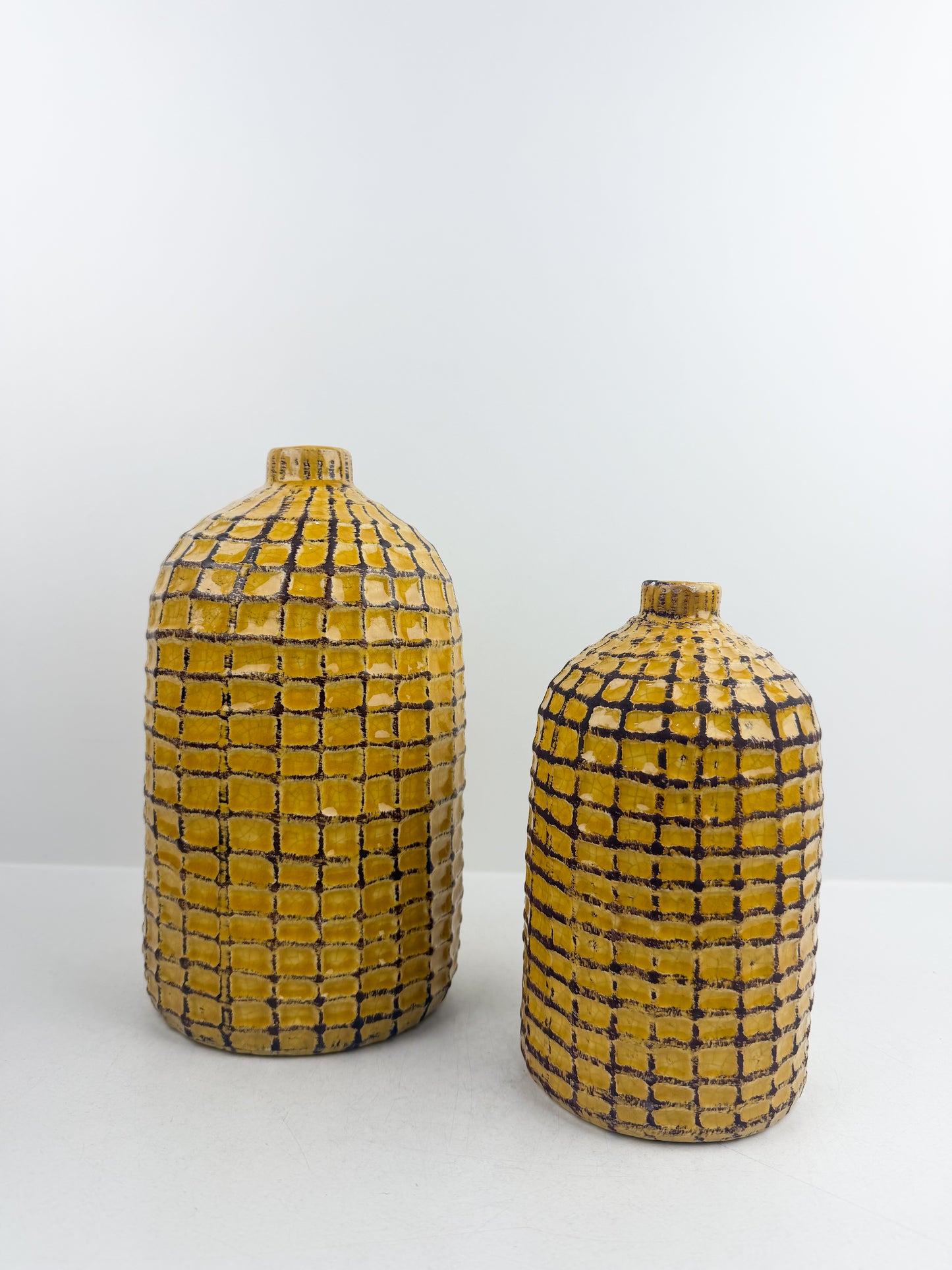 Duo de vases artisanal en céramique motif quadrillé jaune et noir.