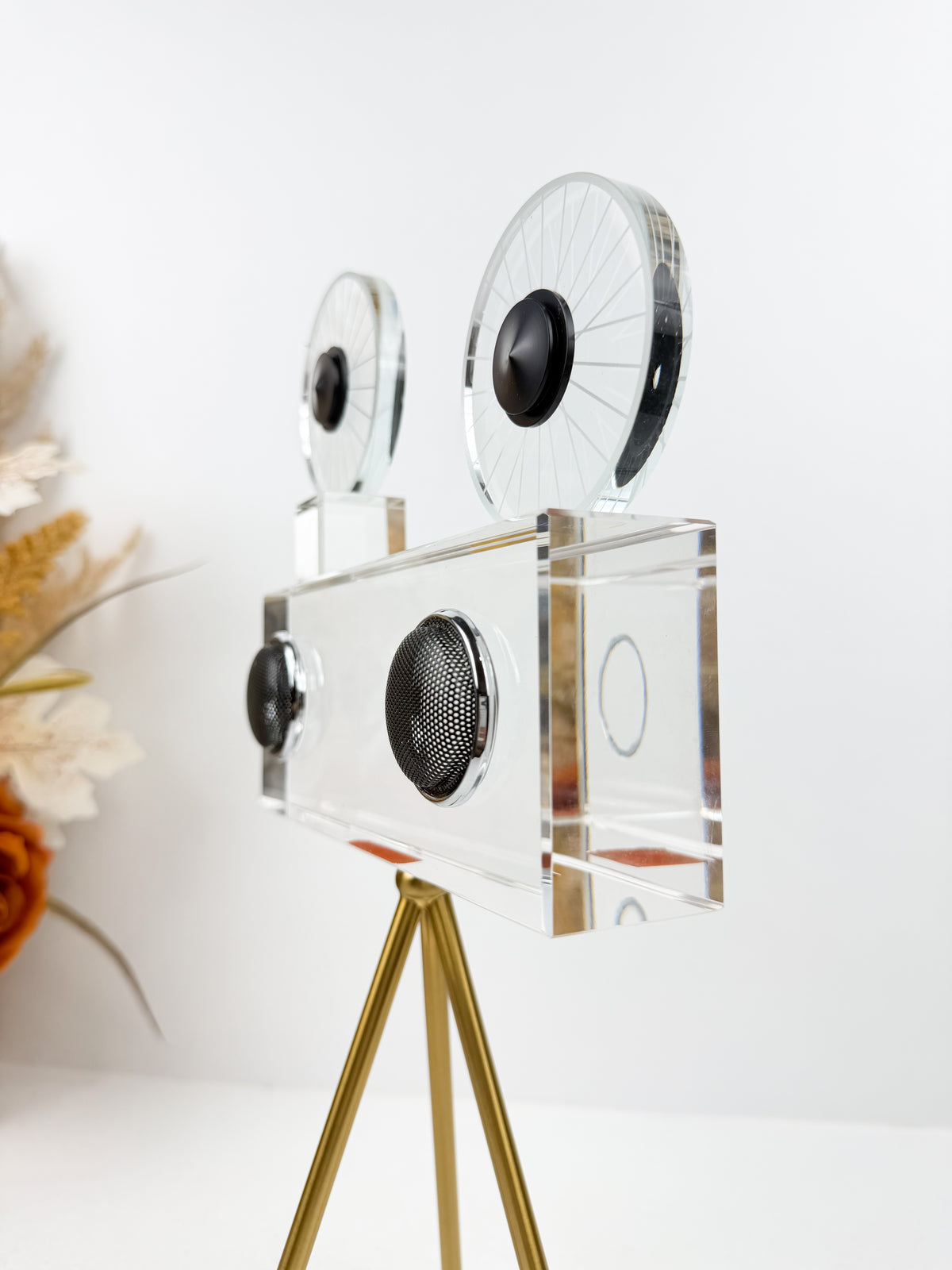Projecteur caméra cinéma vintage sur trépied doré.