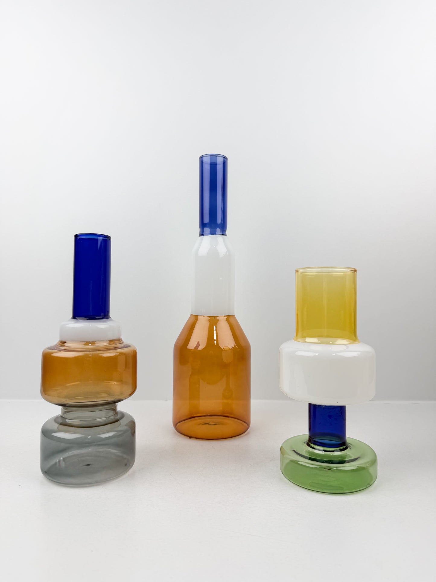 Trio de vases géométriques aux formes épurées et aux couleurs variées.