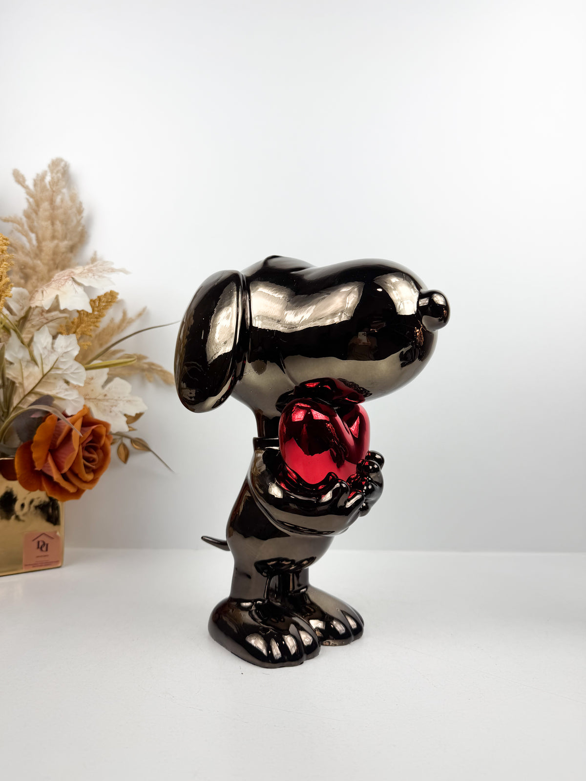 Figurine décorative représentant le célèbre personnage de Snoopy tenant un cœur.