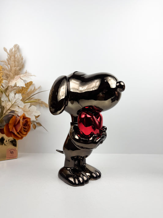 Figurine décorative représentant le célèbre personnage de Snoopy tenant un cœur.