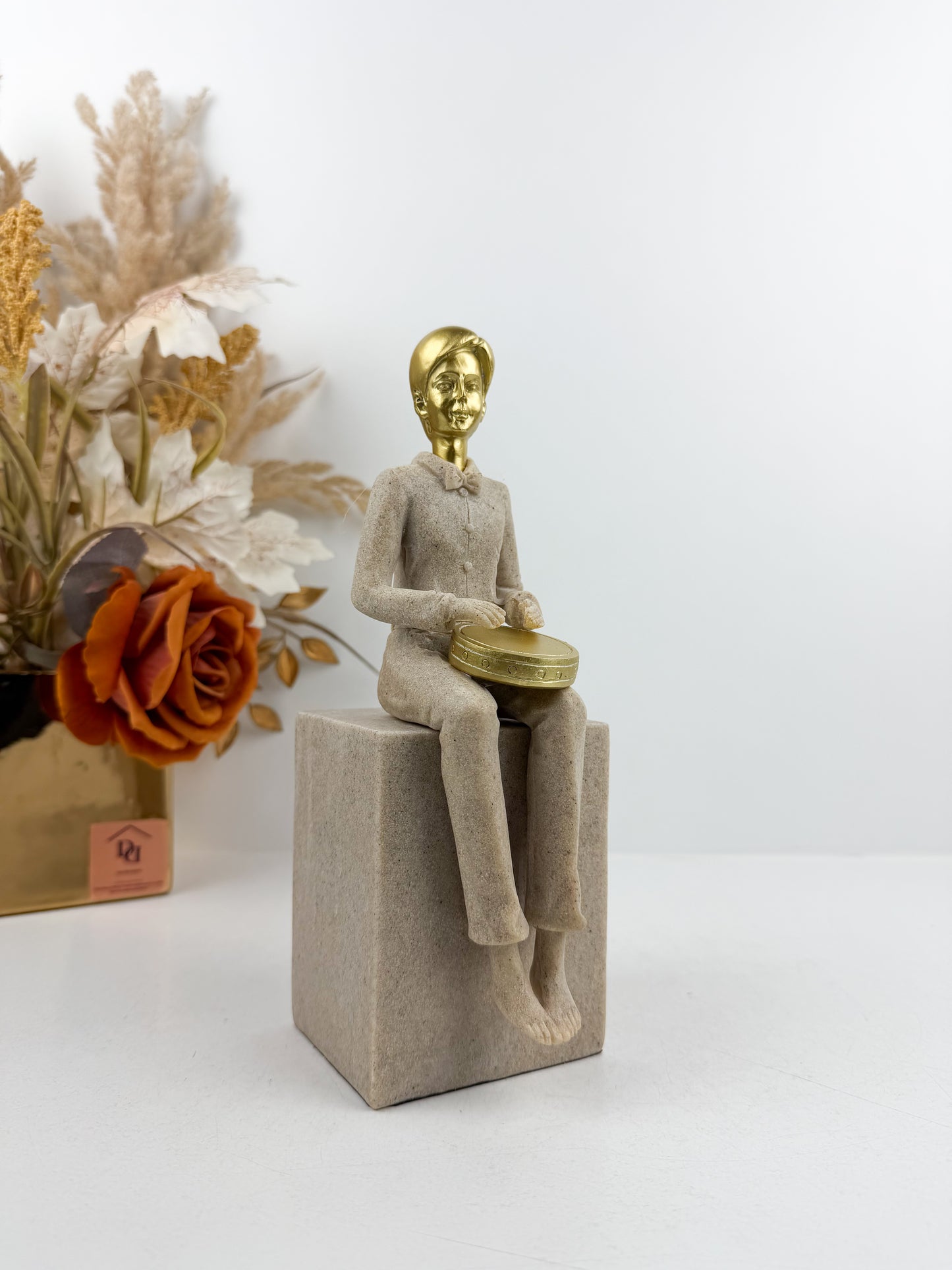 Figurine décorative représentant un musicien assis jouant du tambour
