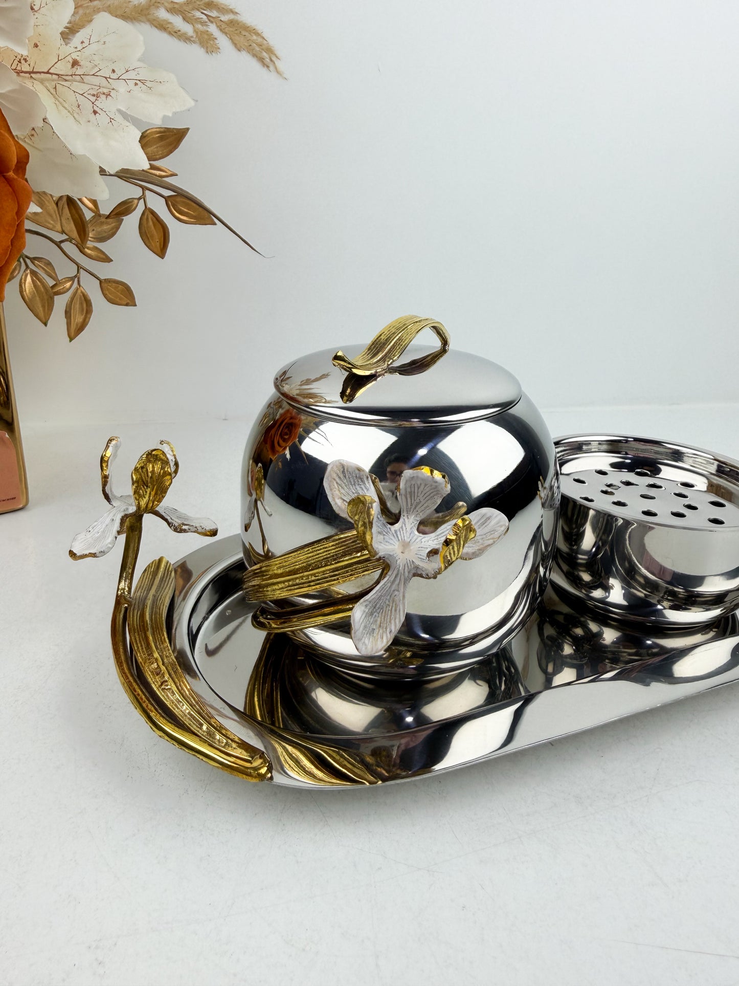 Ensemble de brûleur d'encens élégant en métal argenté de détails floraux.