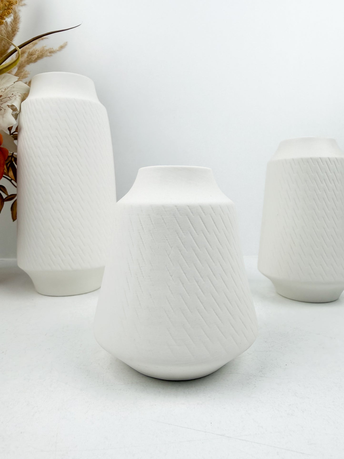 Ensemble de trois vases blancs élégants aux finitions mates qui apportent une touche de sophistication à votre intérieur