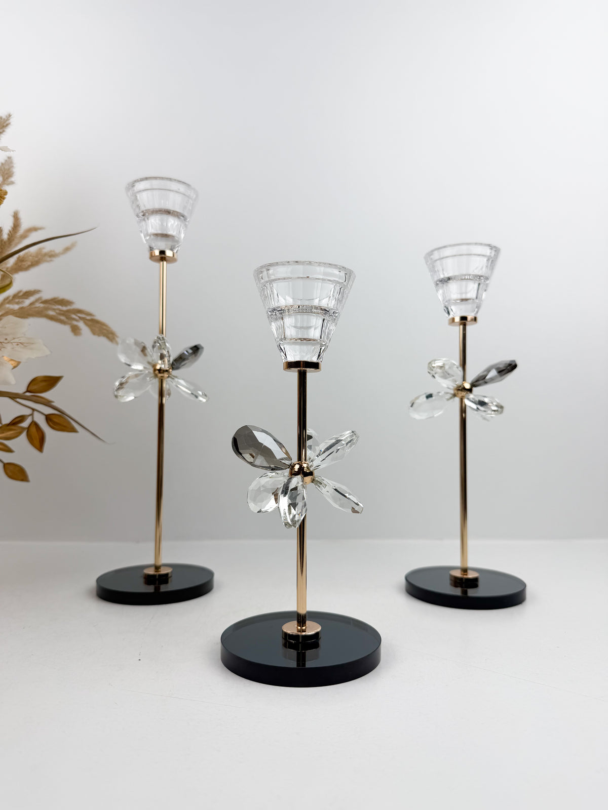 Trio de Bougeoirs décoratif contemporain fleur en cristal sur un socle noir.