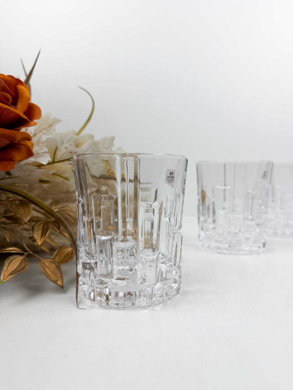 Service de six verres à thé transparents en verre ciselé à motifs géométriques en relief.