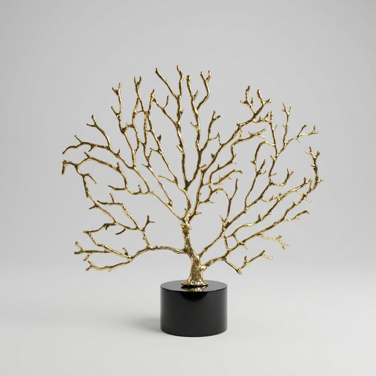Arbre décoratif sculptural doré sur un socle en cristal noir.