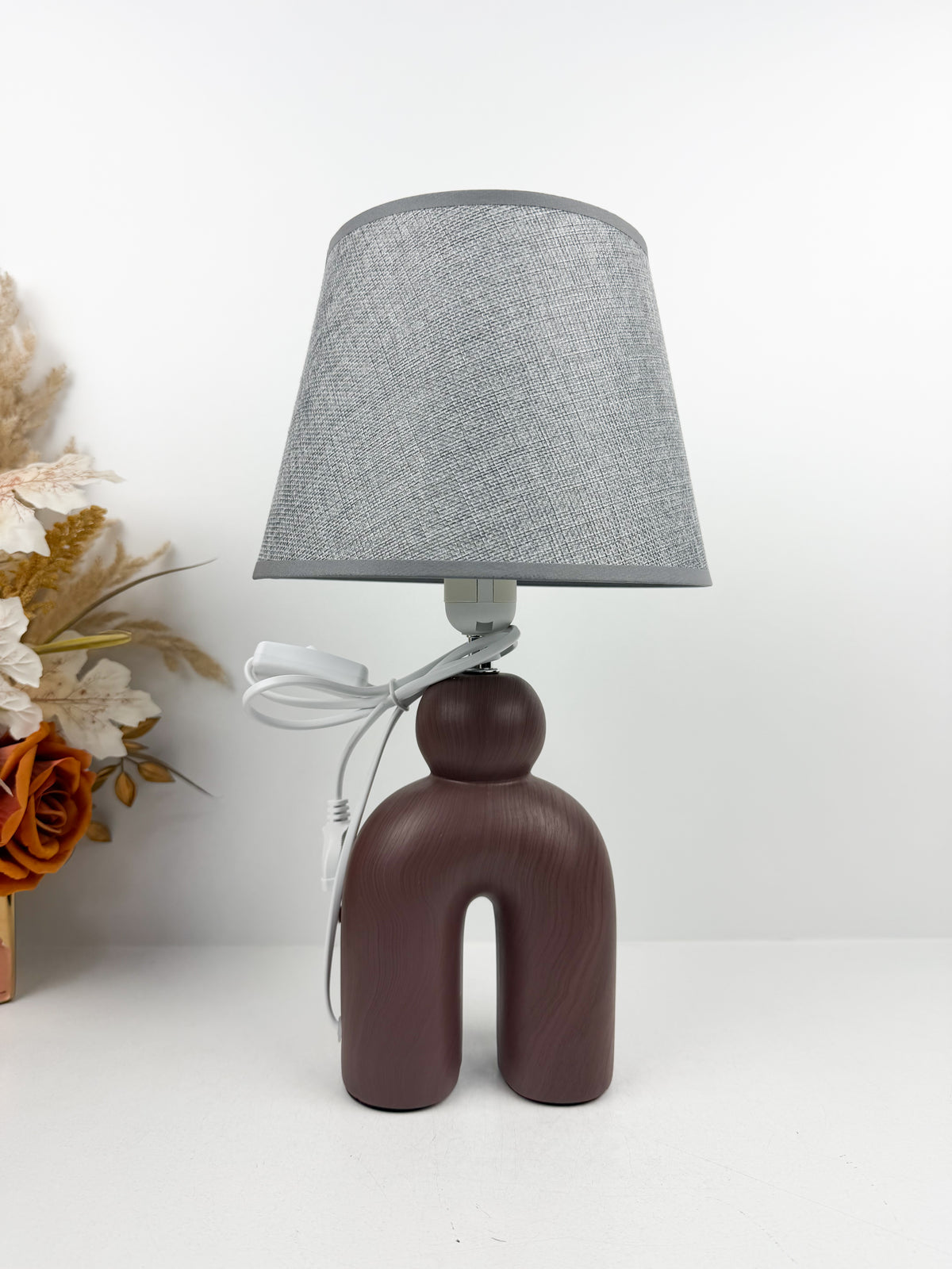 Lampe à Poser Sculpturale de pied en céramique mat d'un abat-Jour gris texturé.