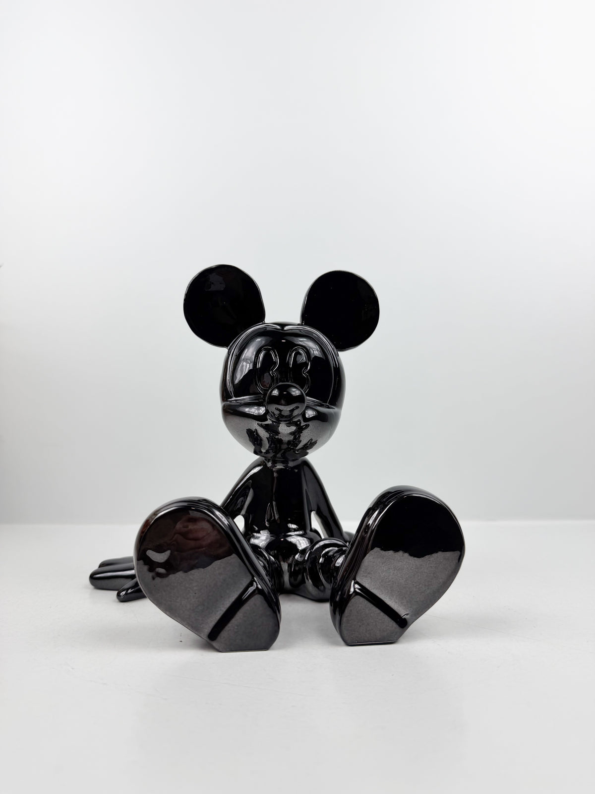 Statuette décorative en résine de Mickey Mouse en position assise.