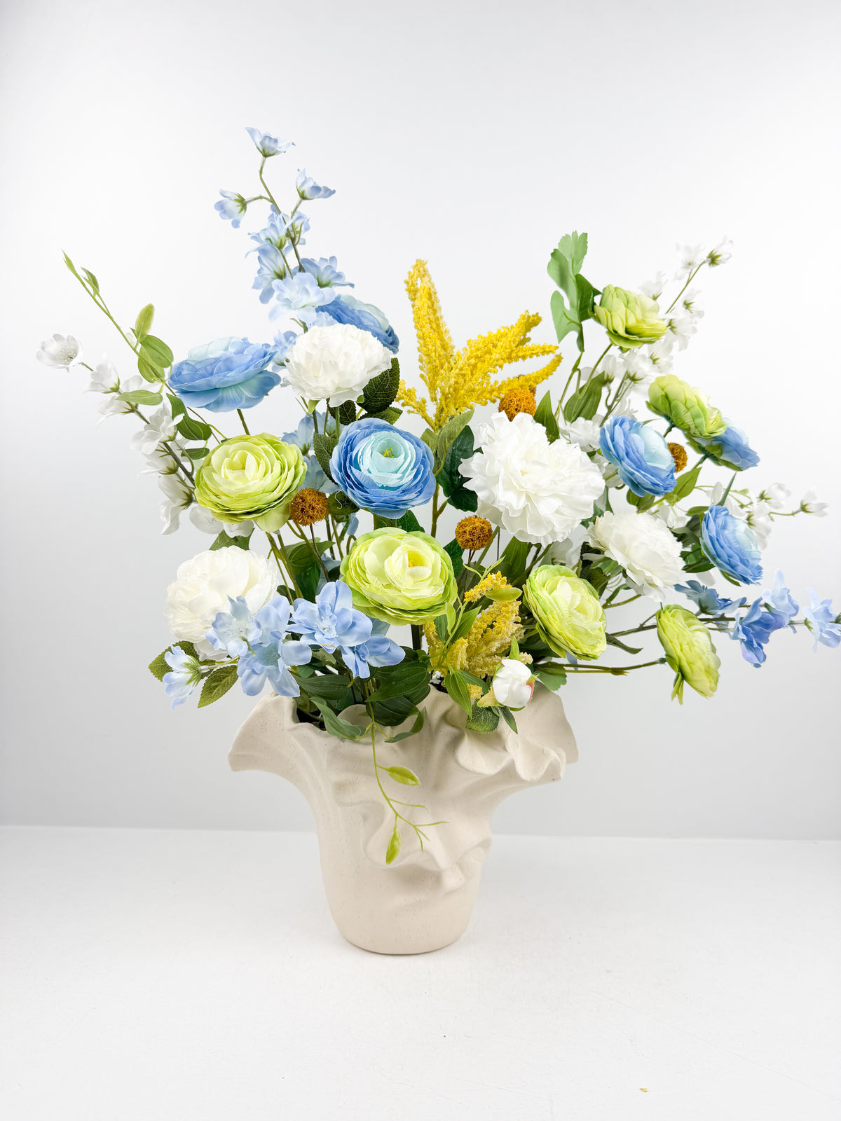 Fleurs artificielles dans un vase en céramique texturée au design original.