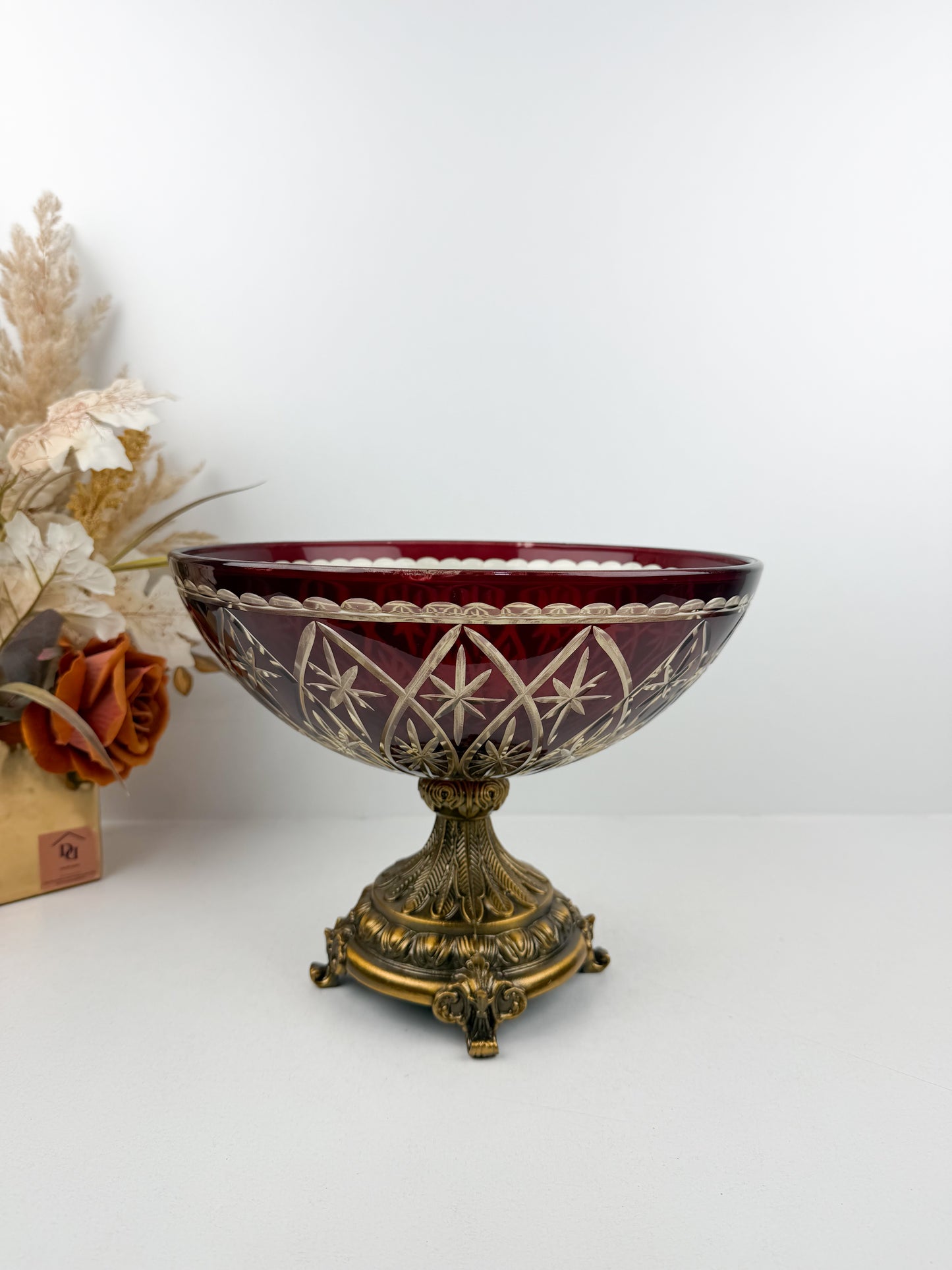 Présentoir en cristal rouge d'une grande finesse, reposant sur un pied en métal de qualité supérieure.