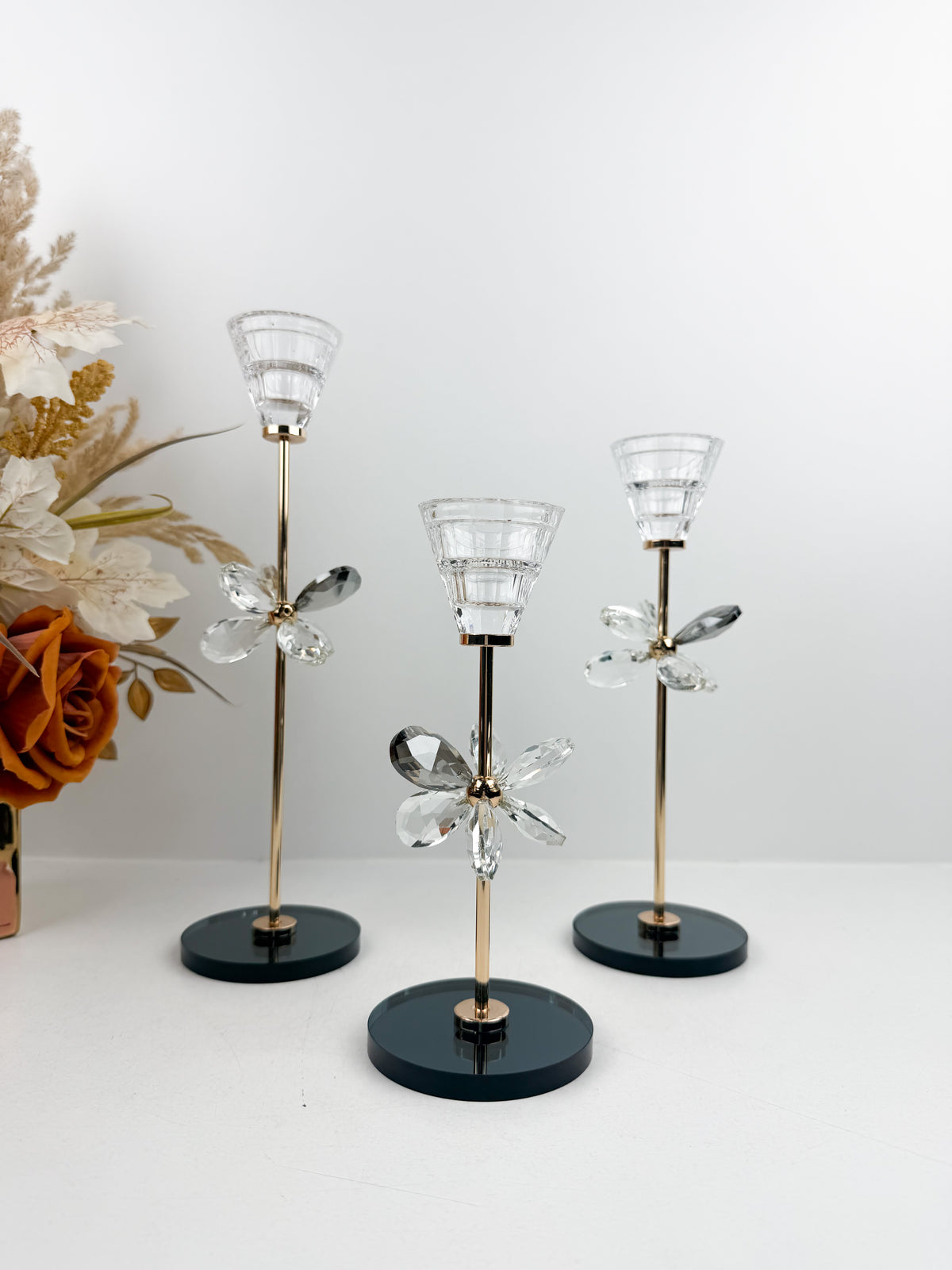 Trio de Bougeoirs décoratif contemporain fleur en cristal sur un socle noir.