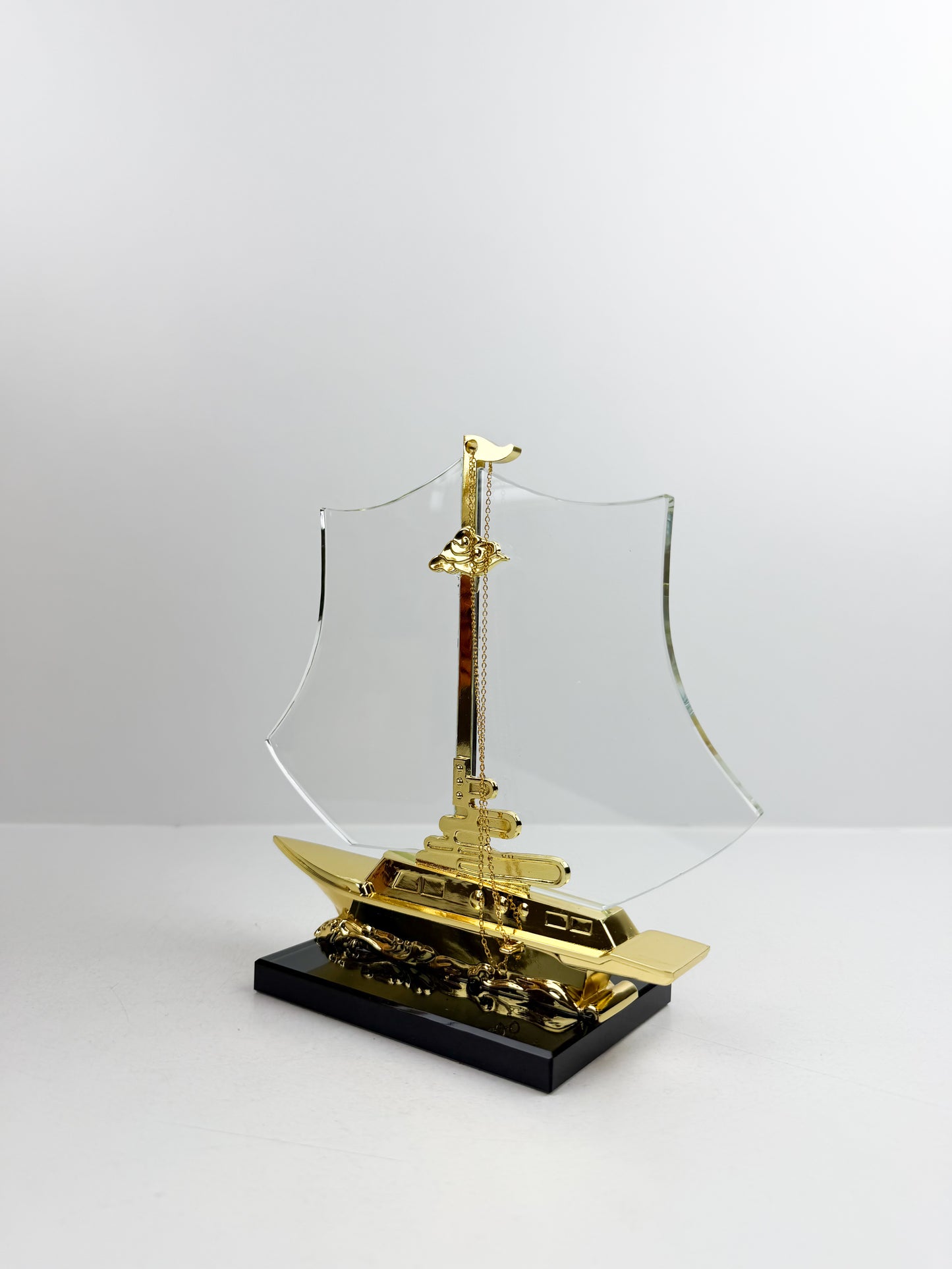 Bateau décoratif doré reposant sur un élégant socle noir