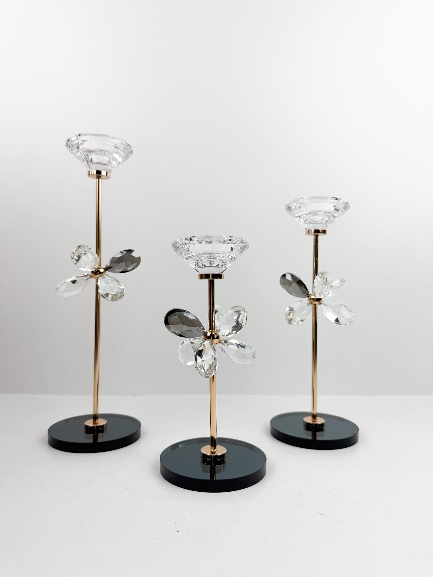 Trio de Bougeoirs contemporain fleur en cristal sur un socle noir.