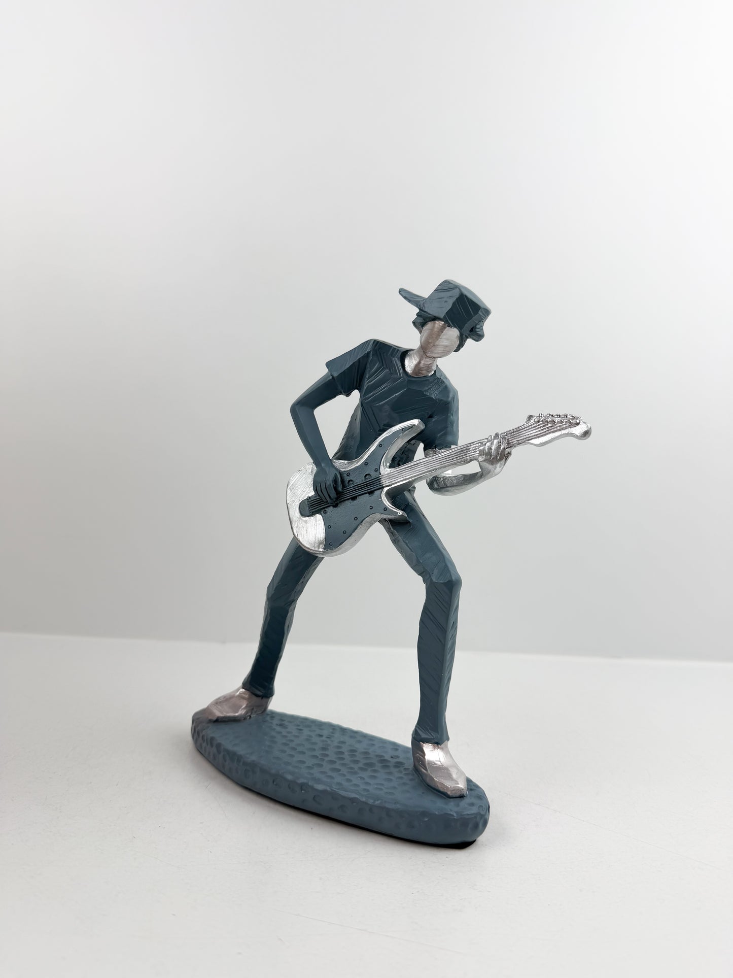 Figurine décorative représentant un guitariste élégant.