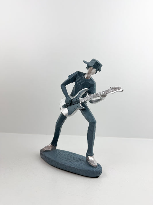 Figurine décorative représentant un guitariste élégant.
