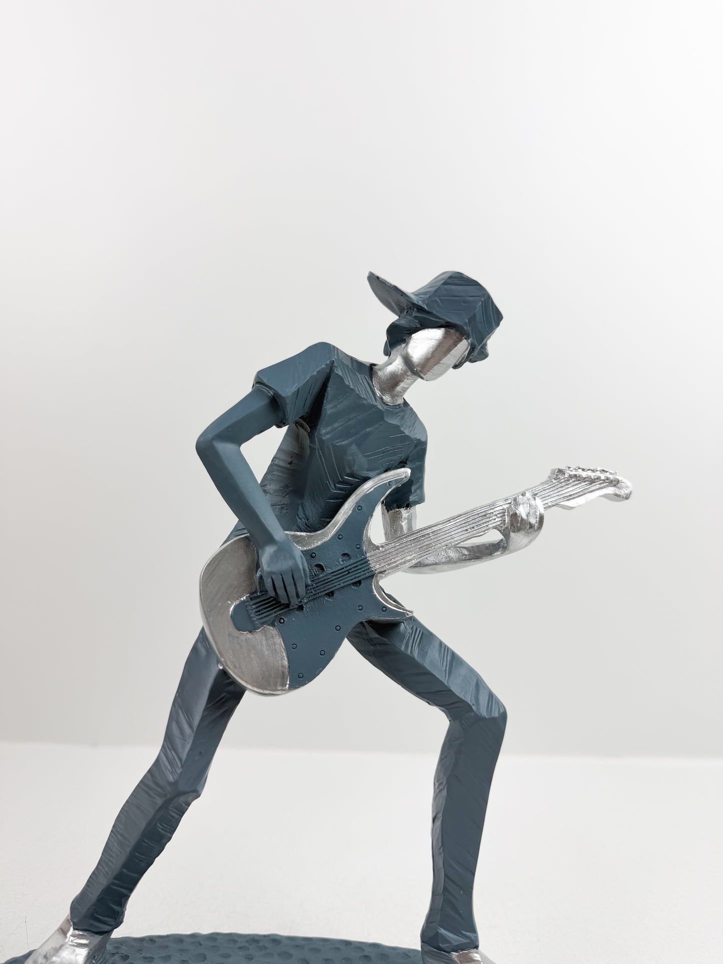 Figurine décorative représentant un guitariste élégant.