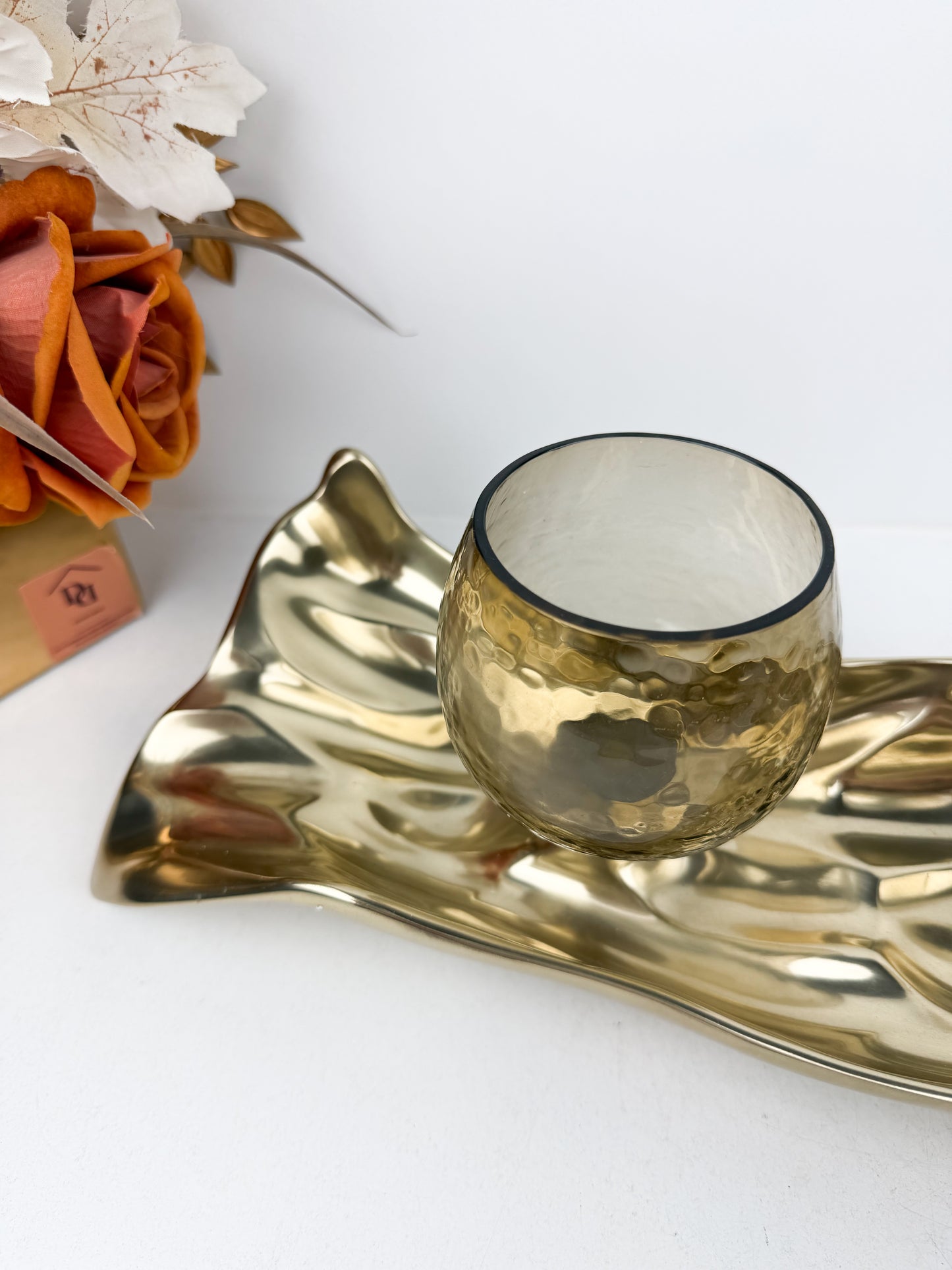 Support de bougie élégant en métal doré aux formes organiques et fluides inspirées de feuilles stylisées.