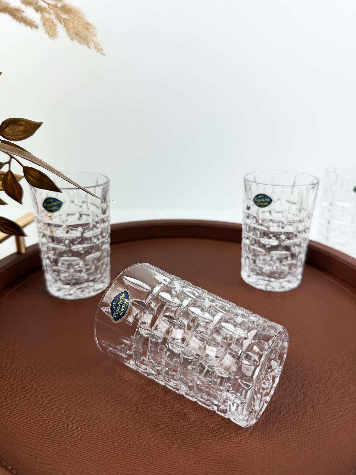 Service de six verres à thé transparents en cristal ciselé à motifs géométriques en relief.