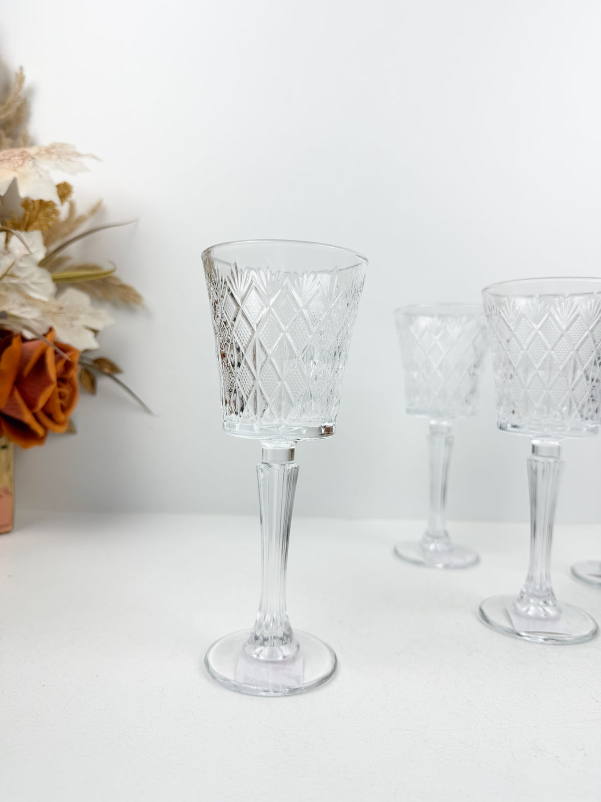 Ensemble de six verres à pied transparents en verre sculpté et ciselé à motifs géométriques.