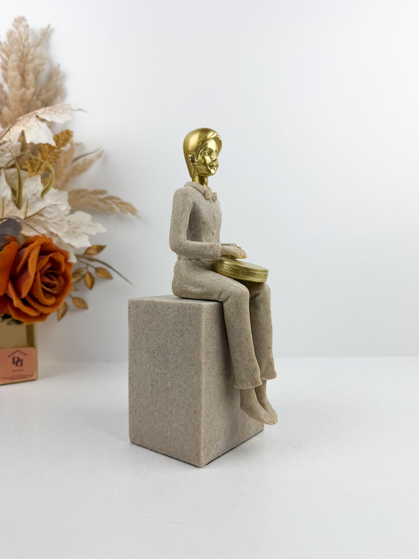 Figurine décorative représentant un musicien assis jouant du tambour