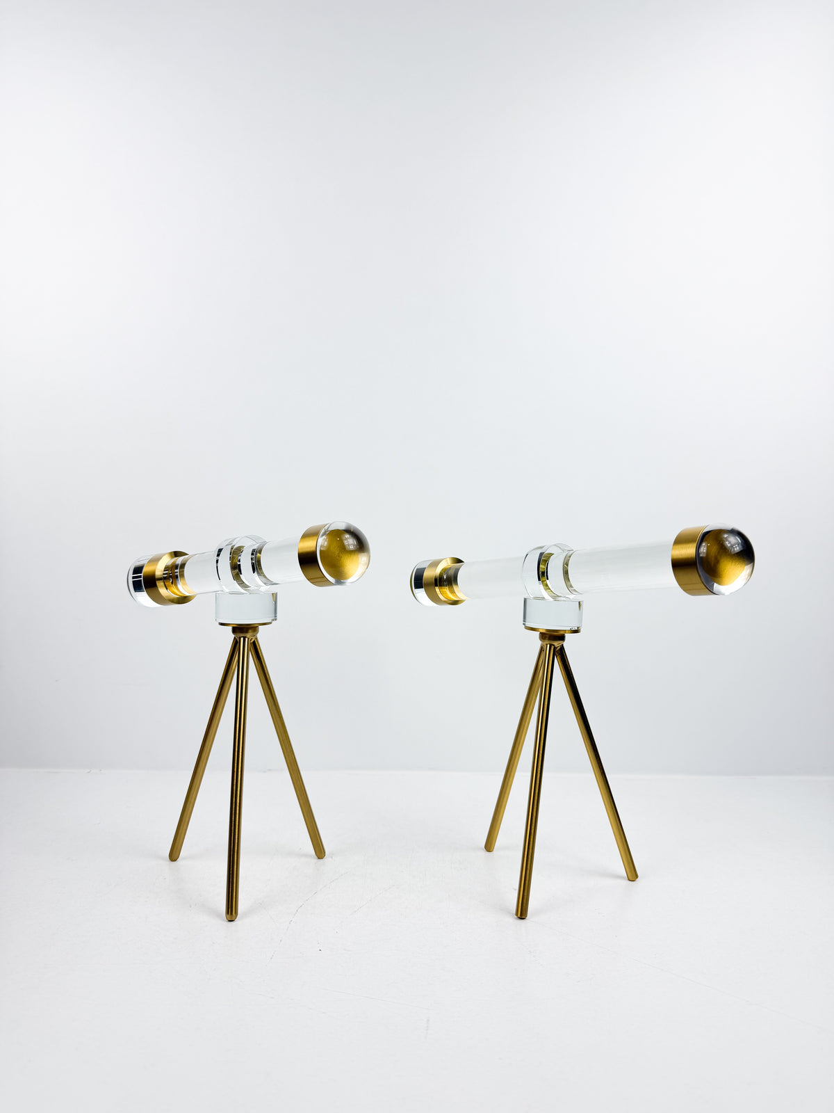 Télescope décoratif en cristal sur trépied en métal doré.