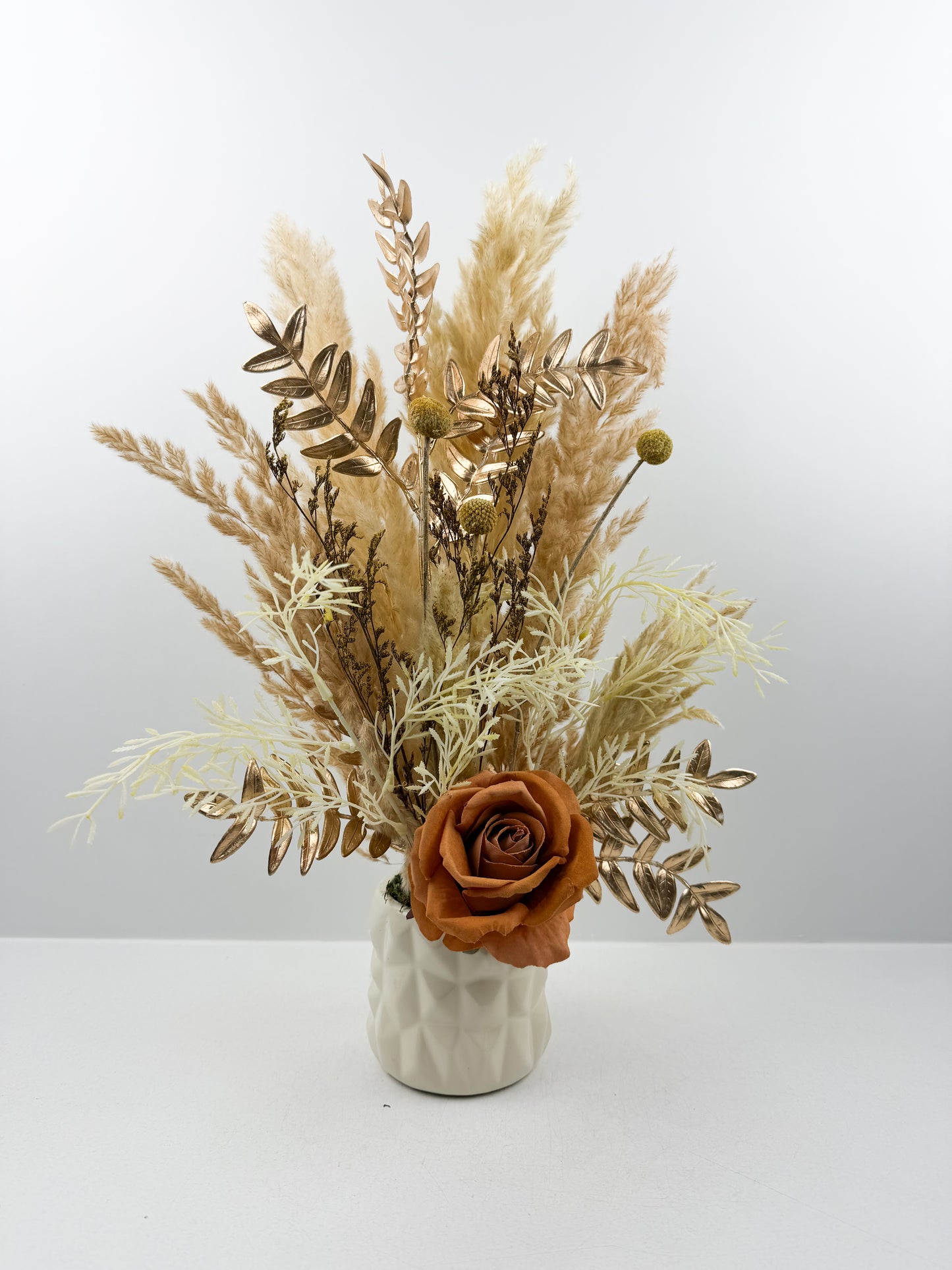 Fleurs séchées beige par une délicate fleur marron dans un vase en céramique beige