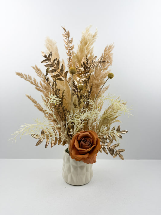 Fleurs séchées beige par une délicate fleur marron dans un vase en céramique beige