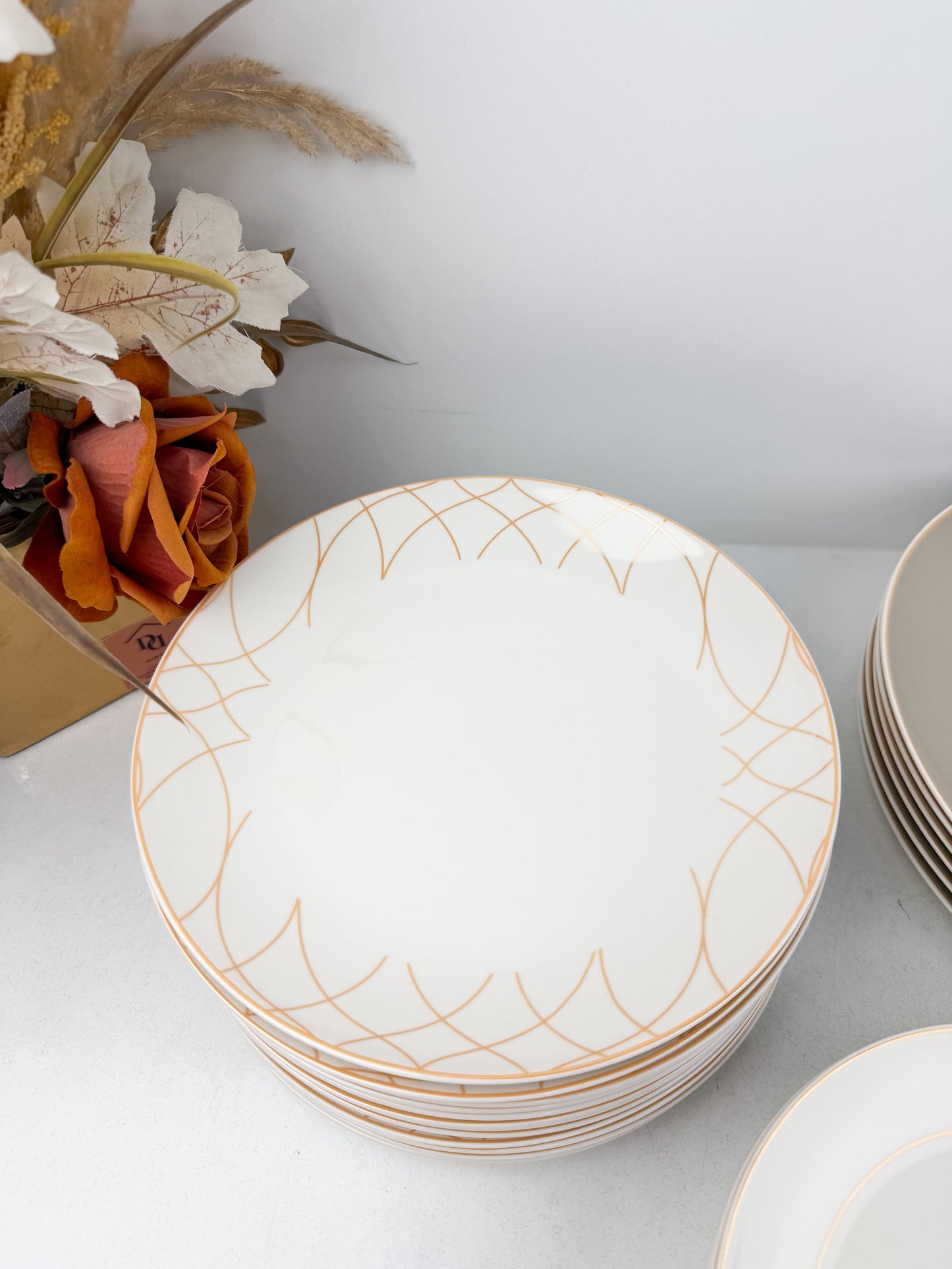 Service de table composé de 36 assiettes en porcelaine de luxe aux motifs élégants beige.
