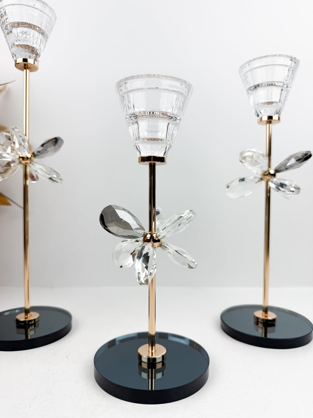 Trio de Bougeoirs décoratif contemporain fleur en cristal sur un socle noir.