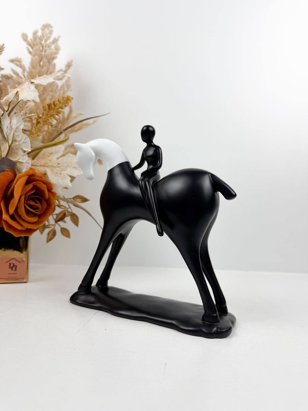 Sculpture décorative équestre moderne en noir et blanc représentant un cavalier stylisé sur son cheval.
