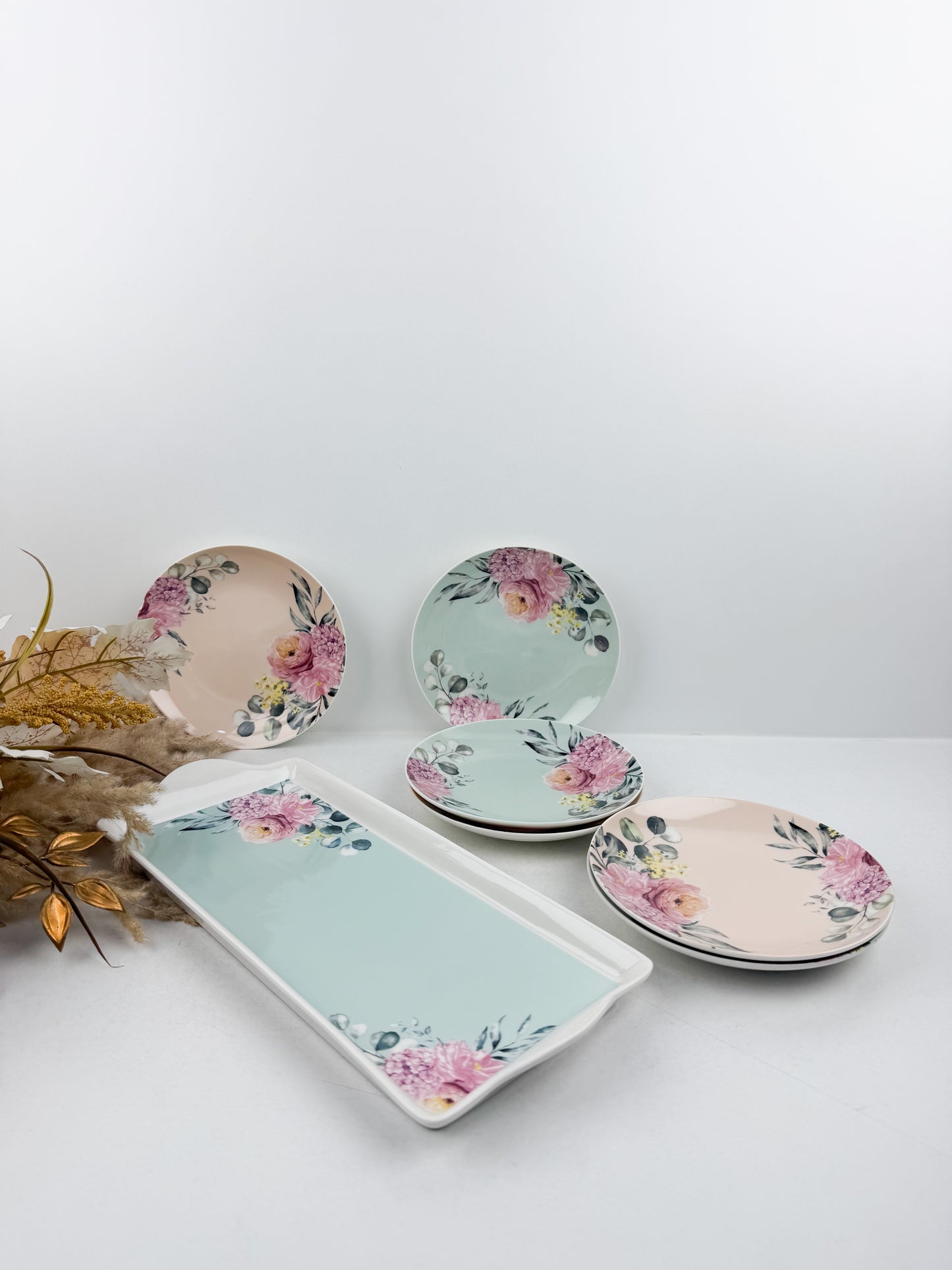 Grande assiette de service accompagnée de six assiettes assorties aux motifs floraux