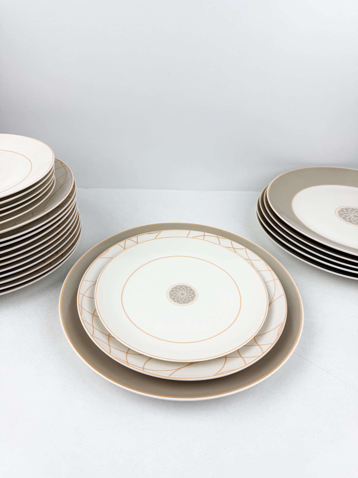 Service de table composé de 36 assiettes en porcelaine de luxe aux motifs élégants beige.