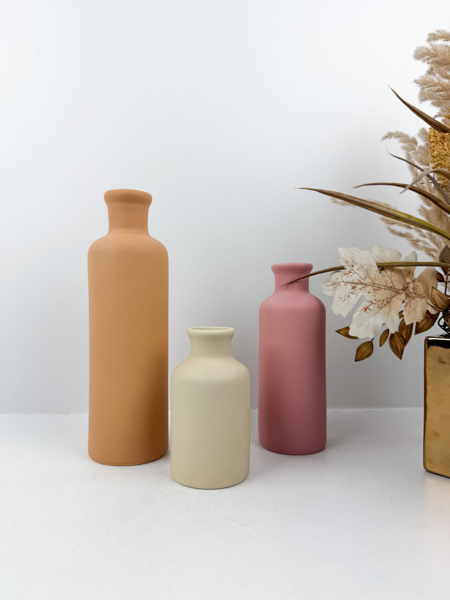 Ensemble de trois vases en céramiques aux couleurs éclatantes épurées et élégantes.