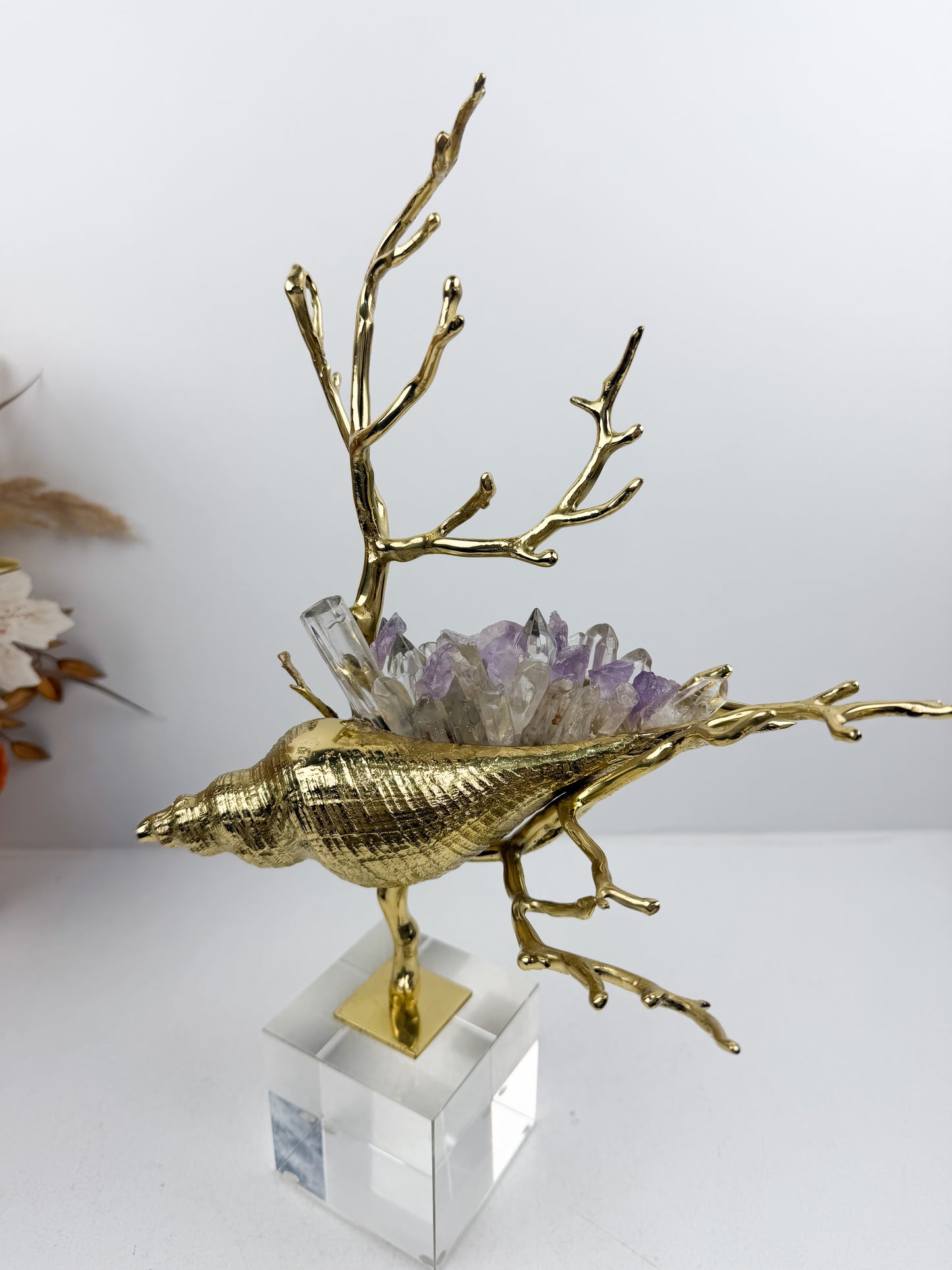 Sculpture de luxe de forme coquillage alliant l'élégance intemporelle du laiton doré aux reflets captivants des cristaux naturels.