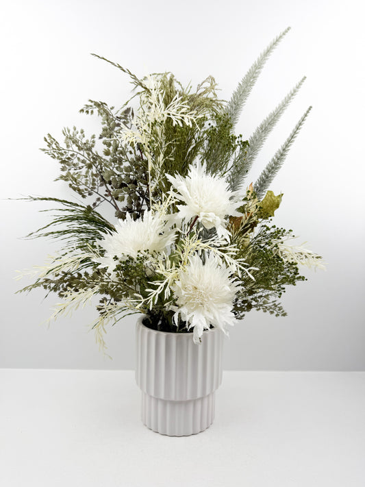 Fleurs artificielles d'une élégance intemporelle dans un vase blanc aux lignes épurées