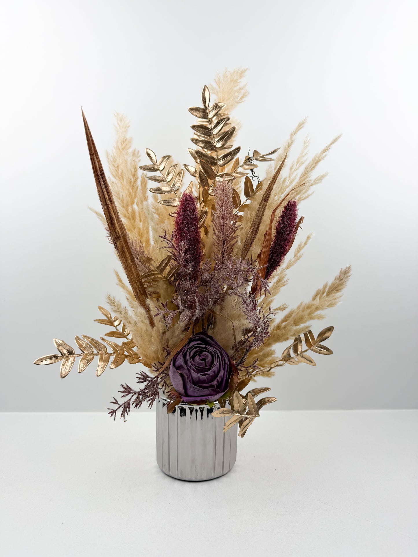 Fleurs séchées violet d'une élégance intemporelle dans un vase argenté aux finitions impeccables.