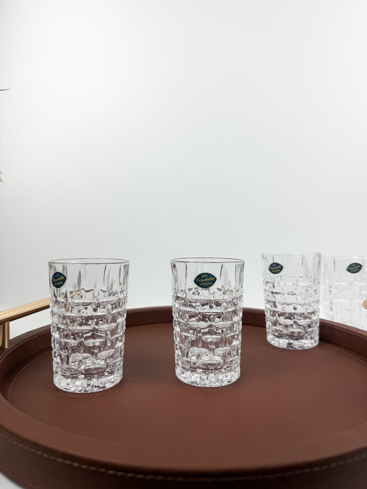 Service de six verres à thé transparents en cristal ciselé à motifs géométriques en relief.