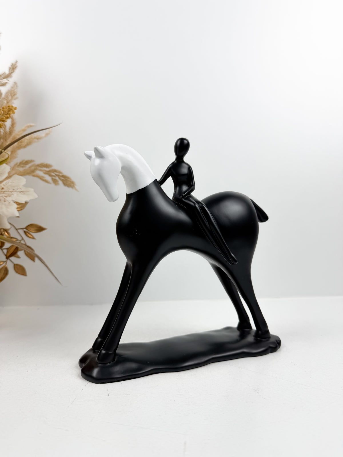 Sculpture décorative équestre moderne en noir et blanc représentant un cavalier stylisé sur son cheval.