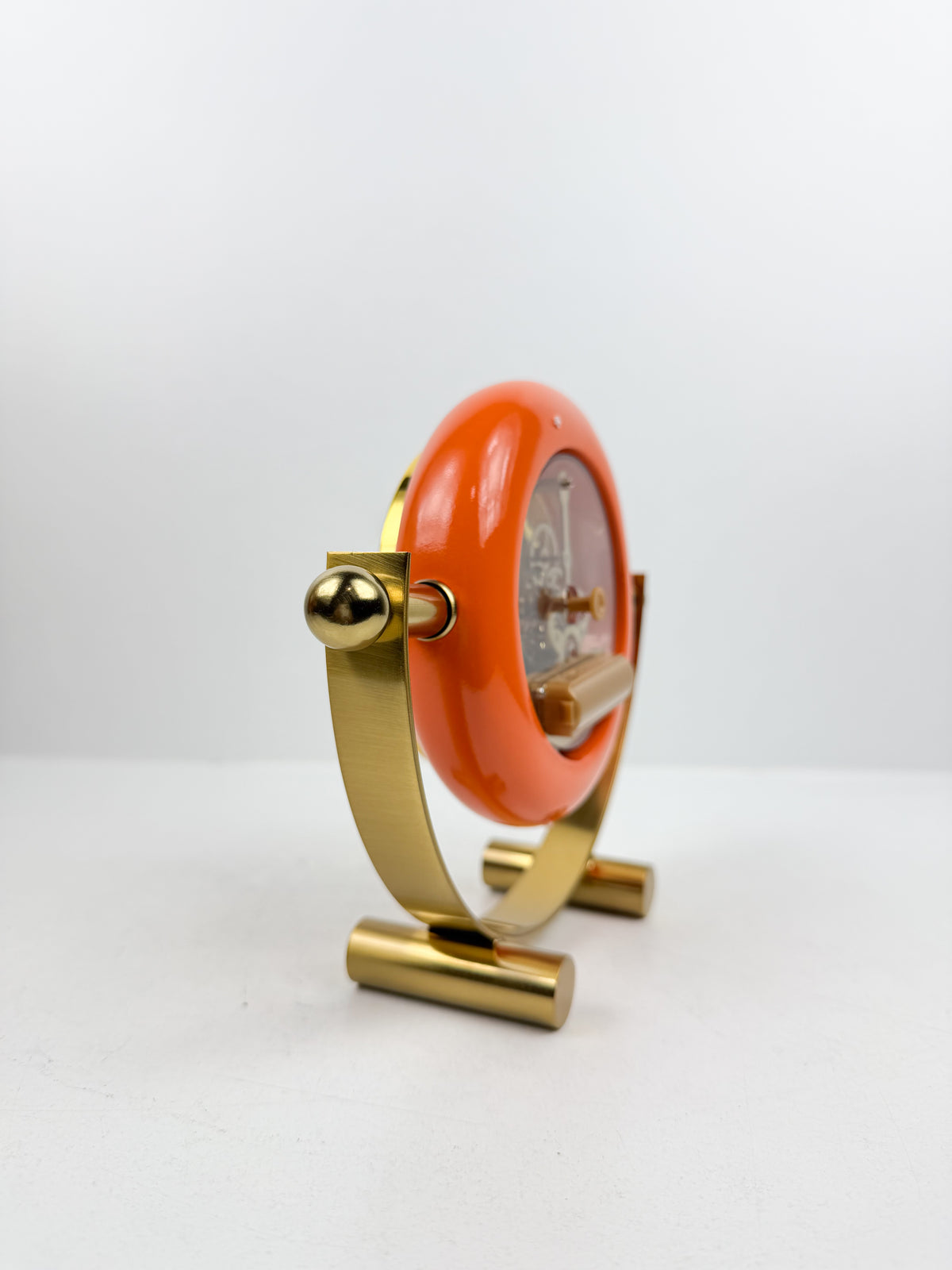 Horloge de table en métal doré de contour orange.