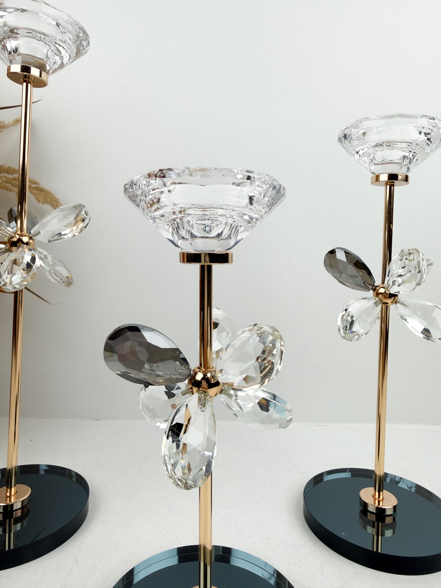 Trio de Bougeoirs contemporain fleur en cristal sur un socle noir.