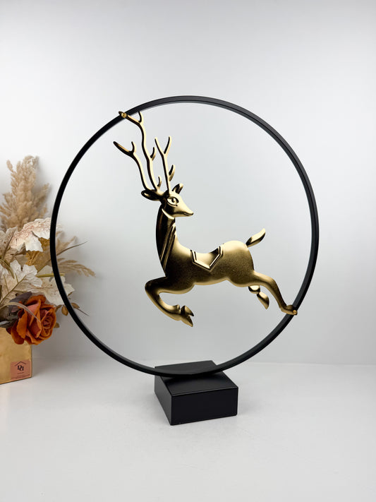Sculpture décorative moderne représentant un cerf doré bondissant, encadré dans un cercle métallique noir épuré.