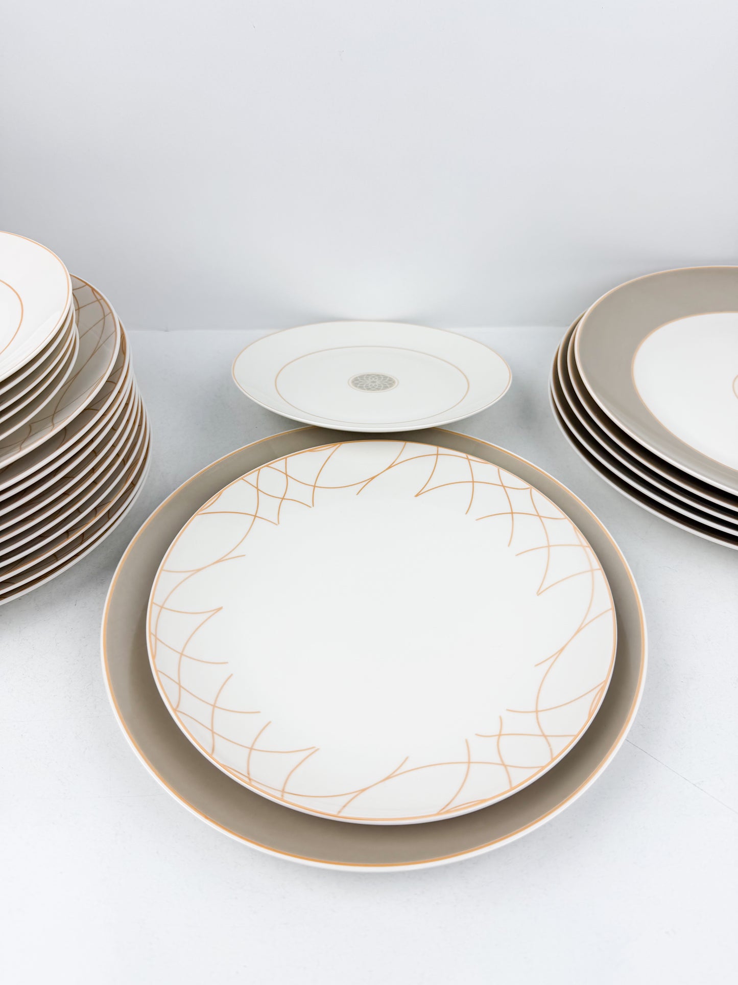 Service de table composé de 36 assiettes en porcelaine de luxe aux motifs élégants beige.