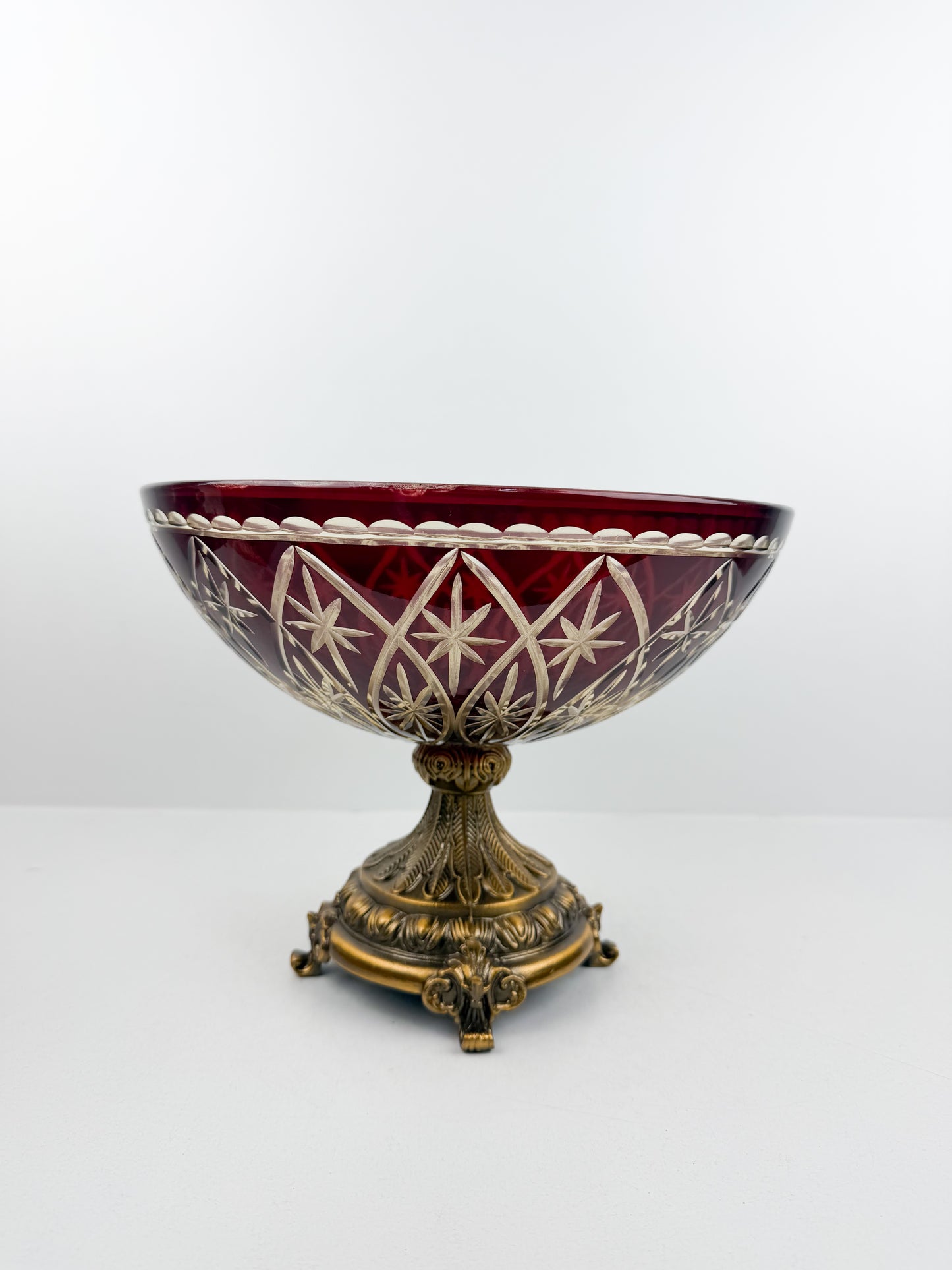 Présentoir en cristal rouge d'une grande finesse, reposant sur un pied en métal de qualité supérieure.