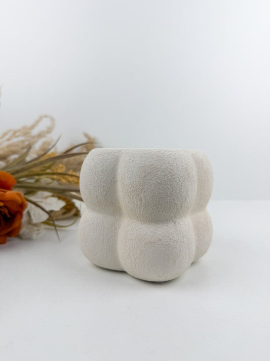 Petit vase en céramique blanc aux finitions texturées et bulles délicates.