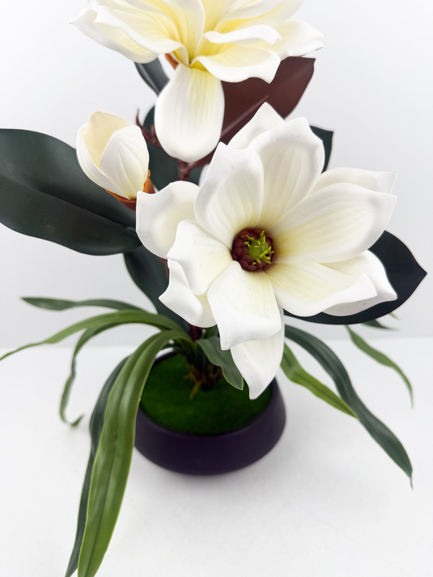 Fleurs artificielles blanches haut de gamme associées à un élégant pot noir